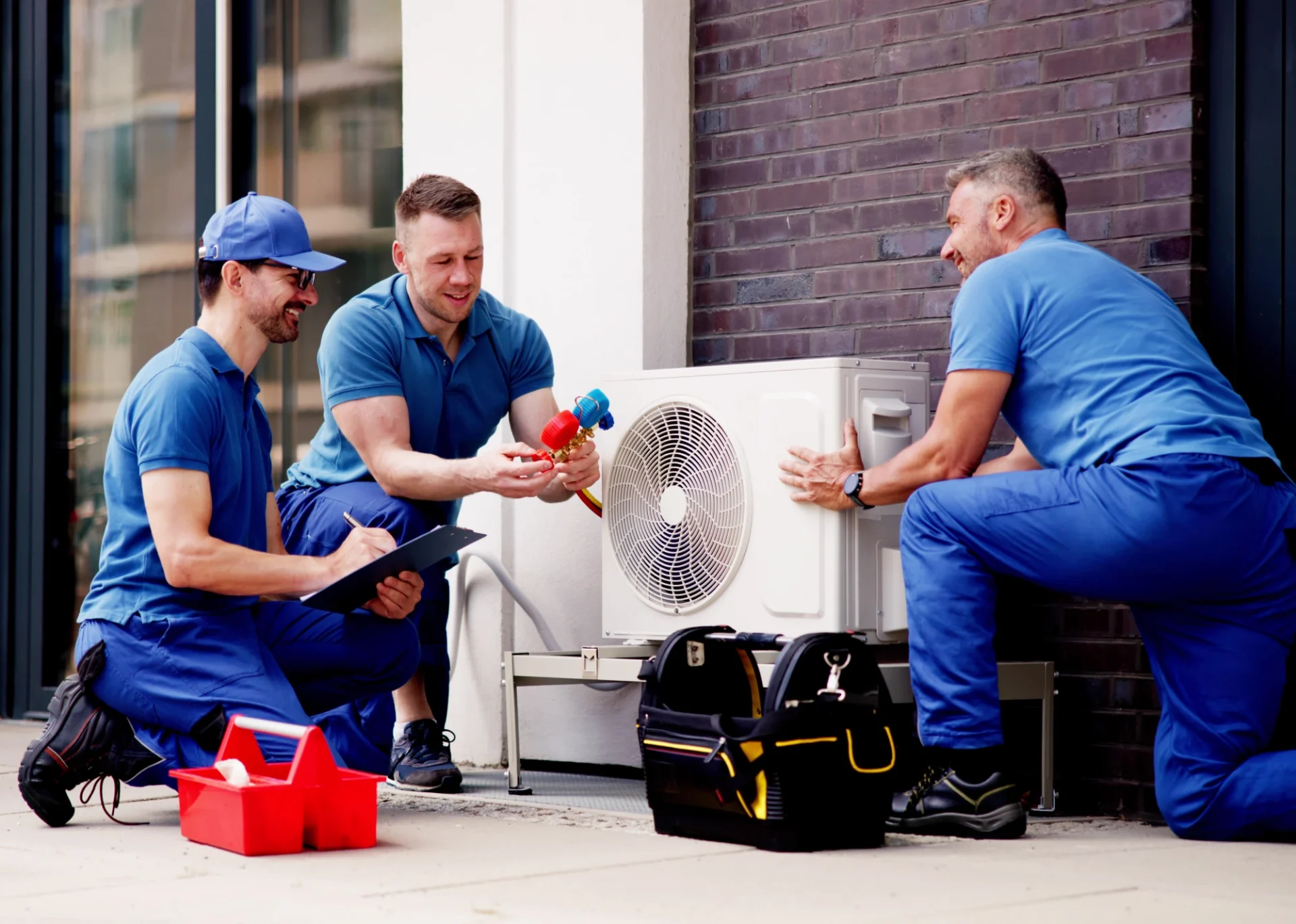 Technicians installing an outdoor air conditioning unit.