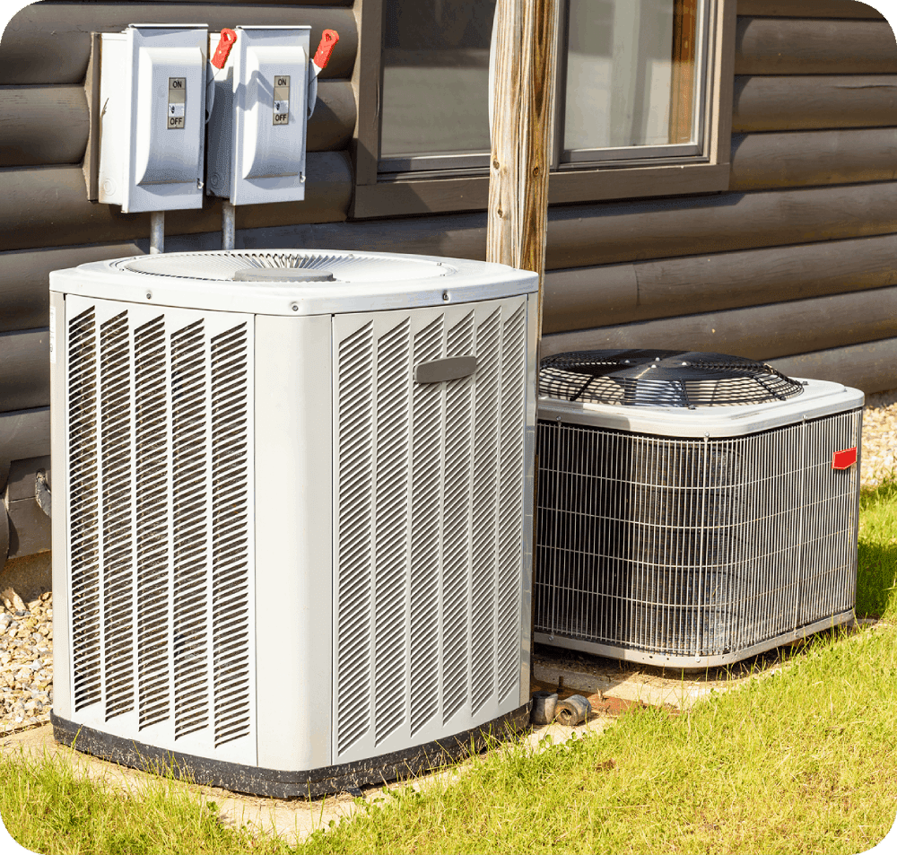Two outdoor air conditioning units on grass.